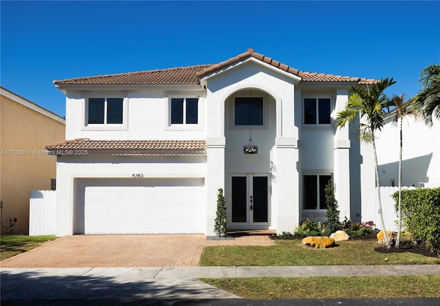 mediterranean / spanish-style home featuring a garage and french doors