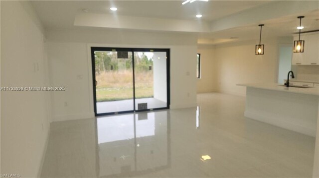 unfurnished room with sink and a raised ceiling
