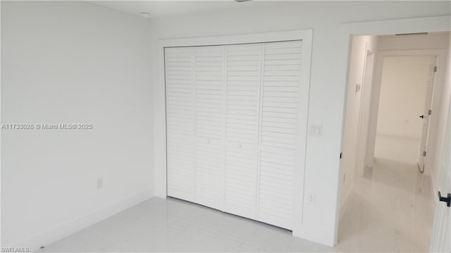 unfurnished bedroom featuring tile patterned floors and a closet