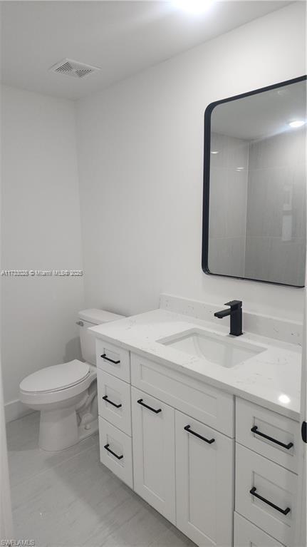 bathroom featuring vanity and toilet