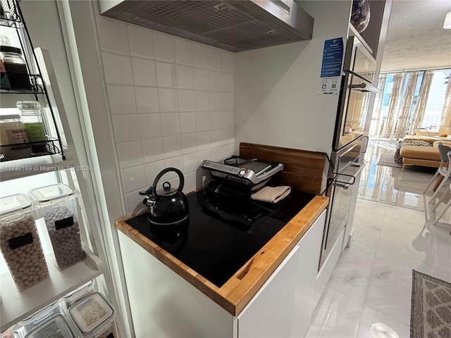 kitchen featuring decorative backsplash and wall chimney range hood