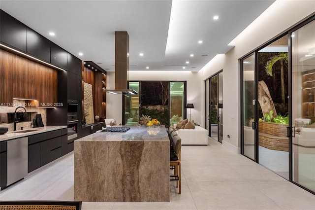 kitchen with sink, a breakfast bar area, tasteful backsplash, stainless steel appliances, and a large island