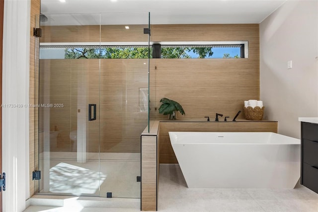 bathroom featuring vanity and independent shower and bath