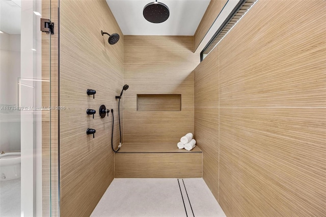 bathroom with a tile shower and a bidet