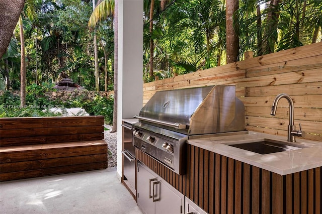 view of patio featuring area for grilling, exterior kitchen, and sink