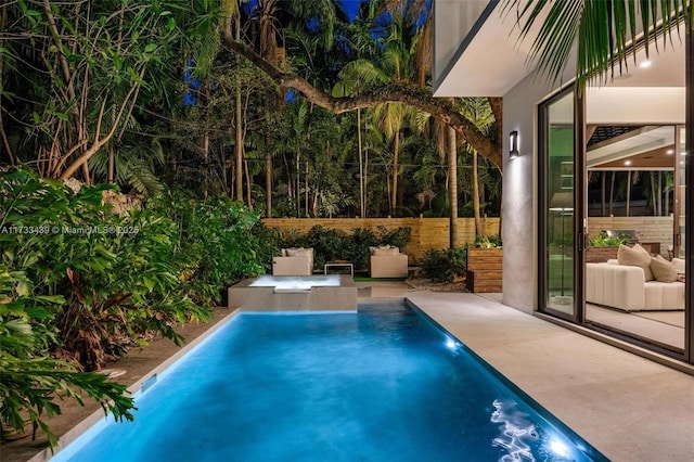 view of swimming pool featuring a hot tub and a patio