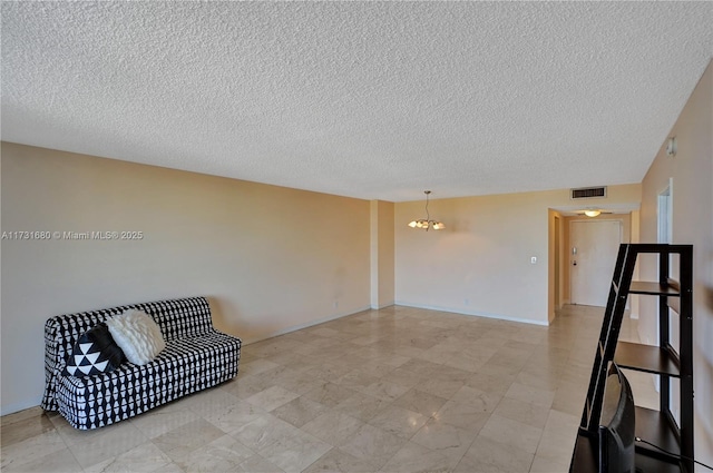 unfurnished room with a textured ceiling and a chandelier