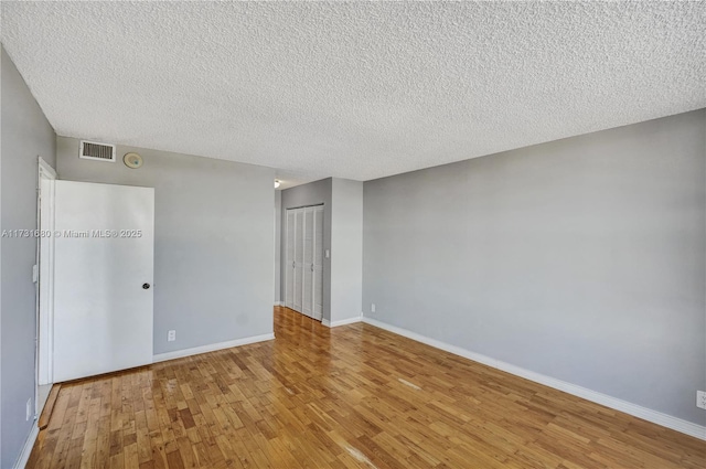 unfurnished bedroom with a closet, a textured ceiling, and light wood-type flooring