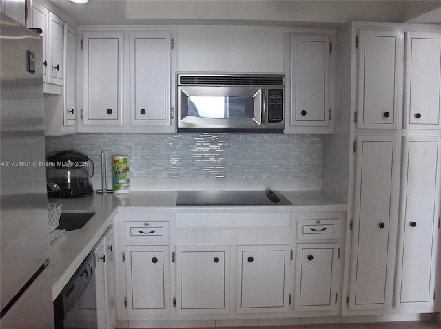 kitchen featuring tasteful backsplash, white cabinets, and black appliances