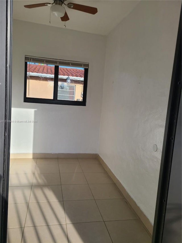 tiled empty room with ceiling fan