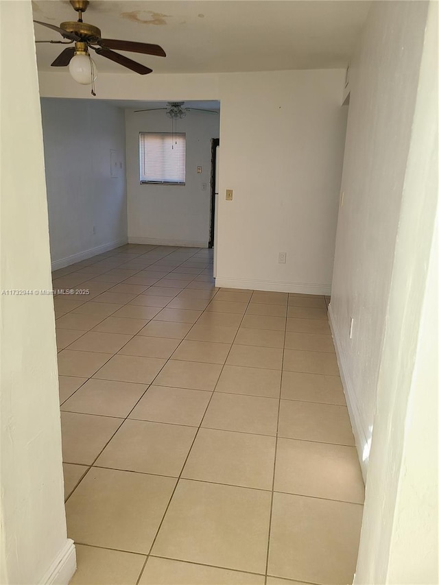 tiled spare room featuring ceiling fan