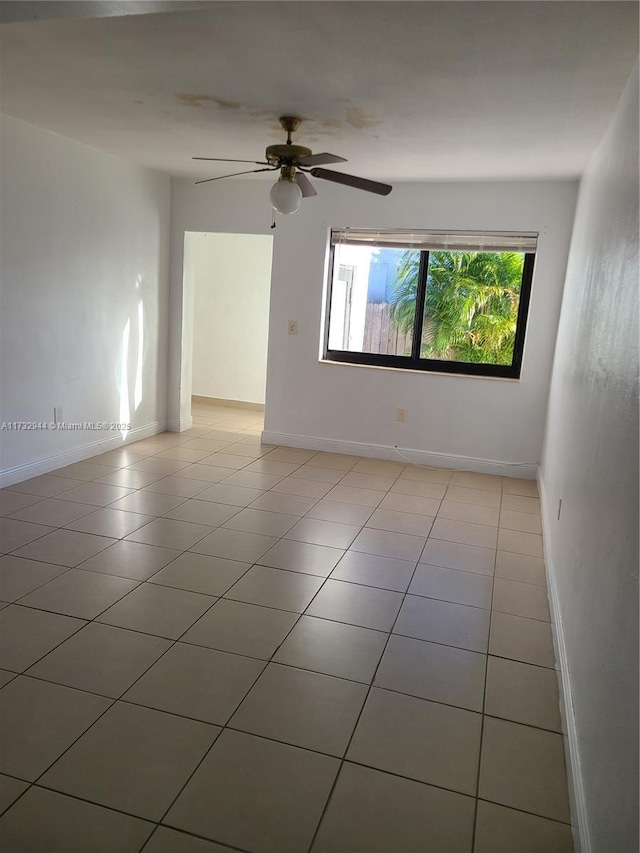 empty room featuring light tile patterned flooring and ceiling fan