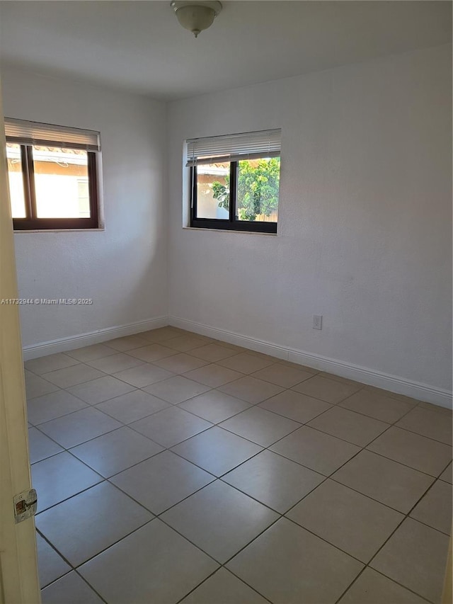 tiled spare room with plenty of natural light