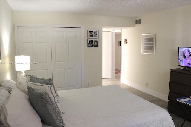 bedroom featuring wood-type flooring and a closet