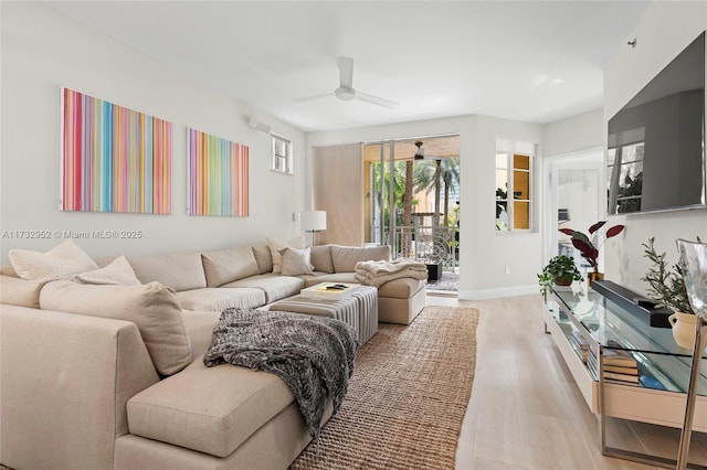 living room with ceiling fan and light hardwood / wood-style flooring