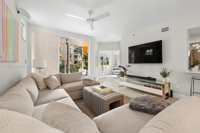 living room featuring wood-type flooring and ceiling fan