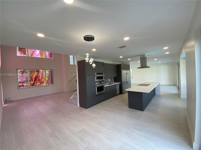 kitchen featuring decorative light fixtures, light wood-type flooring, a kitchen island, island exhaust hood, and black electric stovetop