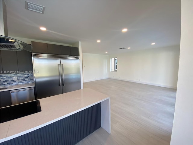 kitchen with stainless steel built in fridge, light hardwood / wood-style flooring, and decorative backsplash