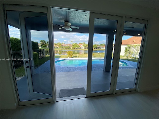 entryway with wood-type flooring, ceiling fan, and a water view