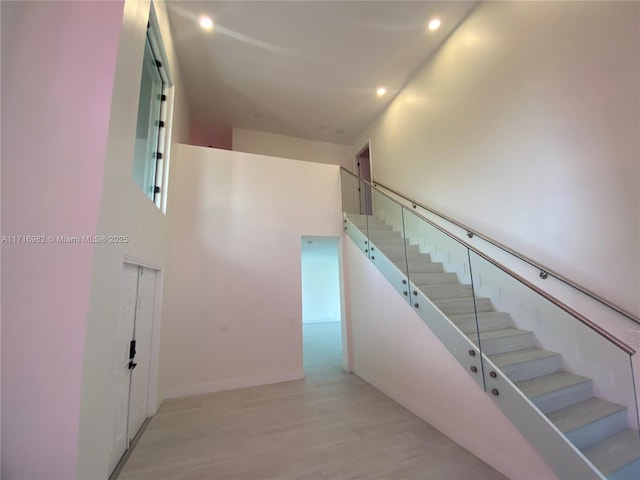 staircase featuring hardwood / wood-style floors and a high ceiling