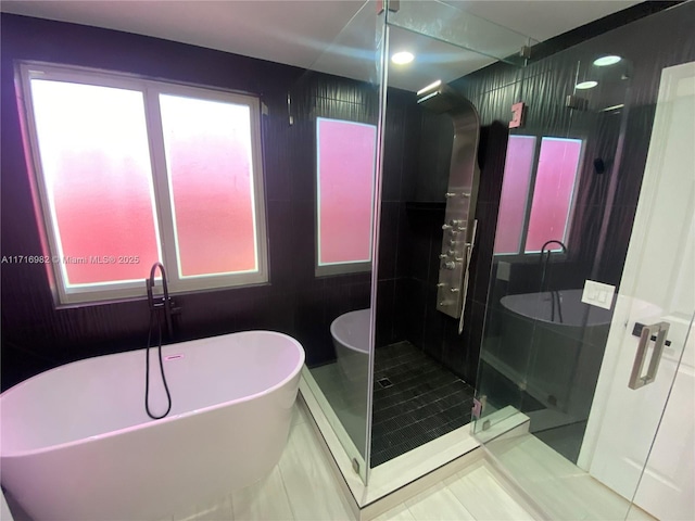 bathroom featuring independent shower and bath, plenty of natural light, and tile patterned floors