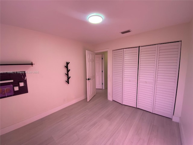 unfurnished bedroom featuring a closet and light hardwood / wood-style flooring