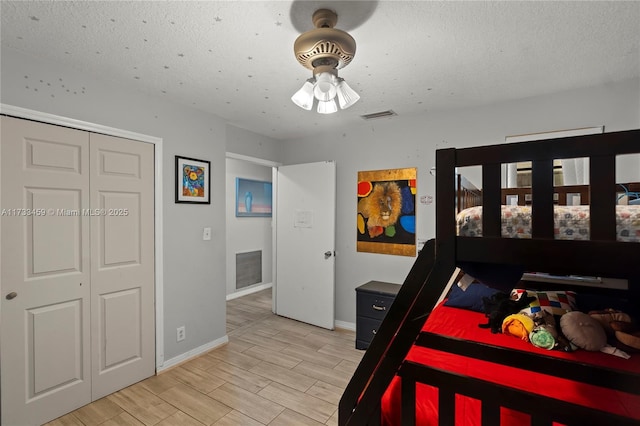 bedroom featuring ceiling fan, a textured ceiling, and a closet