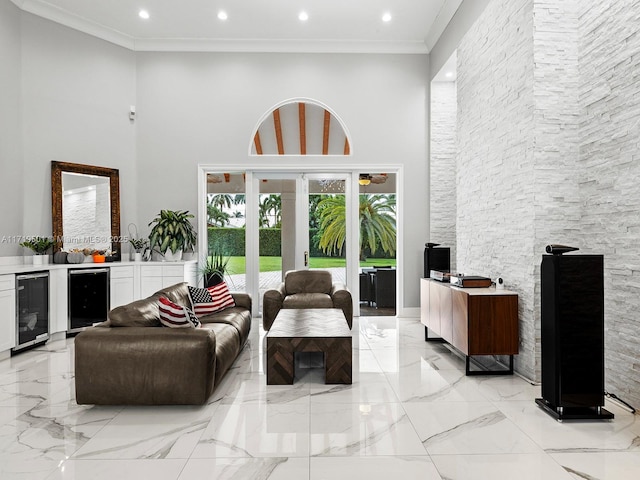 living room with a high ceiling, crown molding, beverage cooler, and french doors