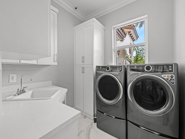 clothes washing area featuring sink, washer and clothes dryer, ornamental molding, and cabinets