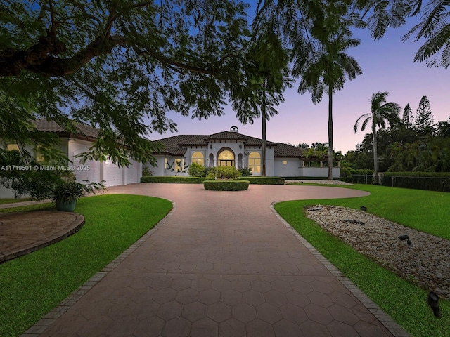 mediterranean / spanish house with a garage and a yard