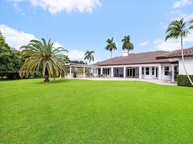 back of property with a yard and a patio area