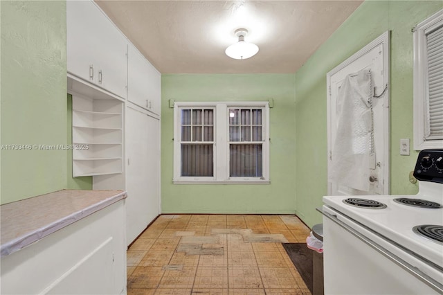 kitchen featuring white range with electric cooktop and white cabinets