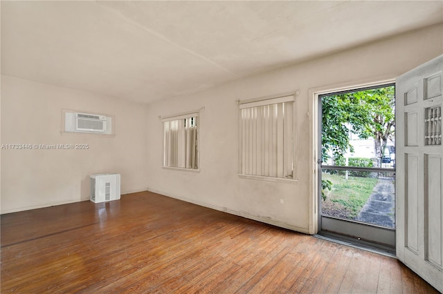 empty room featuring hardwood / wood-style flooring and a wall unit AC