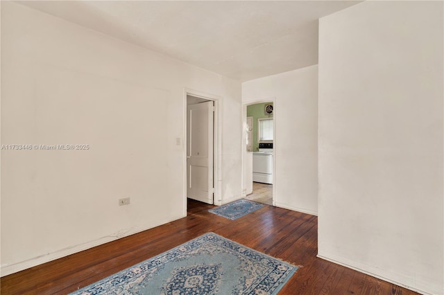 spare room with dark wood-type flooring and washer / dryer