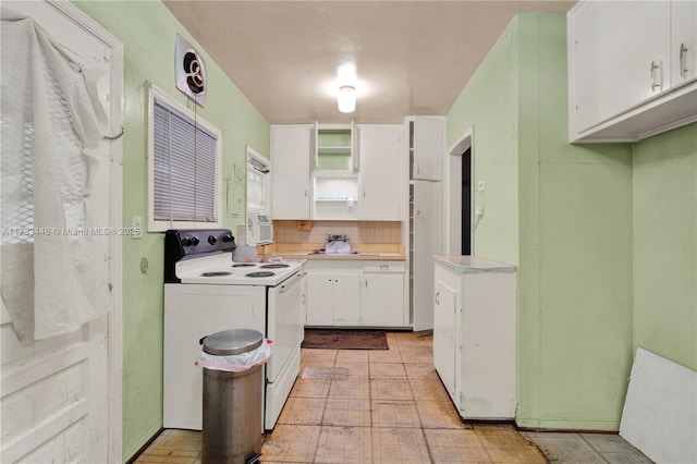 kitchen featuring electric stove, tasteful backsplash, and white cabinets