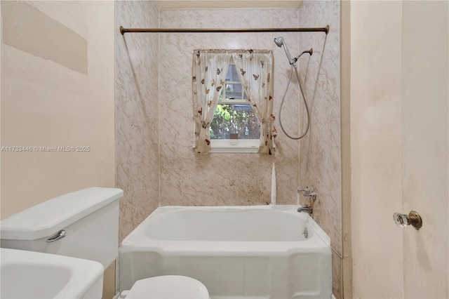 bathroom featuring tiled shower / bath and toilet