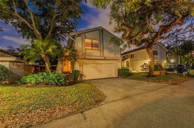 view of front of property featuring driveway, an attached garage, and fence