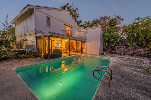 36 Eastmont Rd, Hollywood, FL 33021 - rear view of property featuring an outdoor pool, a patio area, a sunroom, a fenced backyard, and a balcony