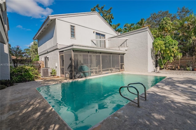 pool with a sunroom, a patio area, and fence