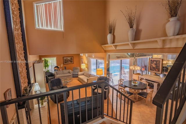 tiled living room featuring a high ceiling and a healthy amount of sunlight