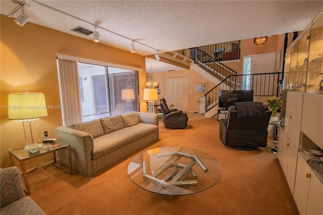 carpeted living room featuring a wealth of natural light, visible vents, stairway, and a textured ceiling