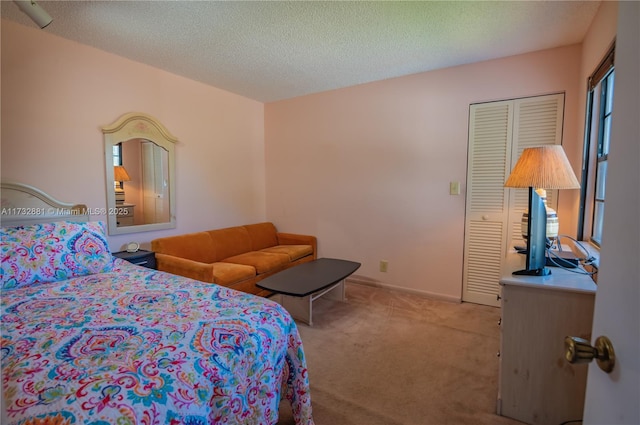 bedroom featuring a textured ceiling, carpet floors, and baseboards