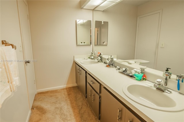 bathroom with double vanity, a sink, and baseboards