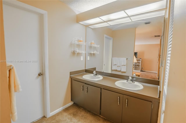 bathroom with double vanity, a sink, and baseboards