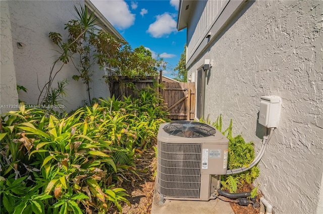 exterior details featuring central air condition unit, fence, and stucco siding