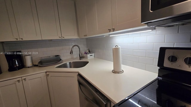 kitchen featuring sink, decorative backsplash, white cabinets, and appliances with stainless steel finishes