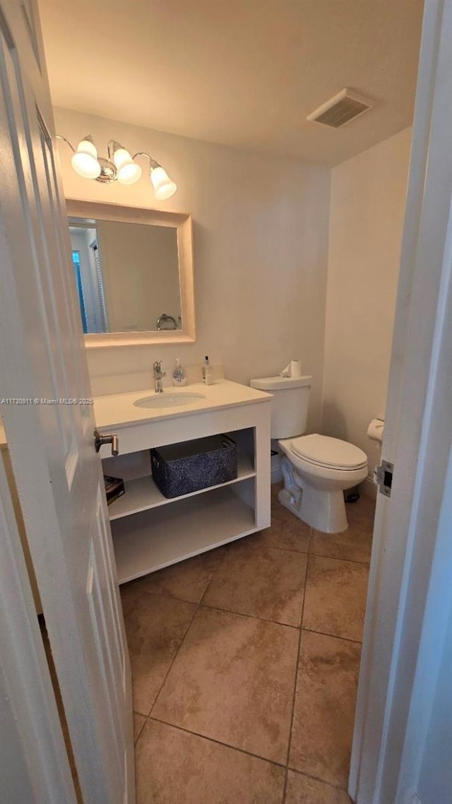 bathroom featuring vanity, tile patterned floors, and toilet