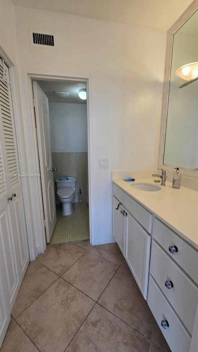 bathroom with vanity, tile patterned floors, and toilet