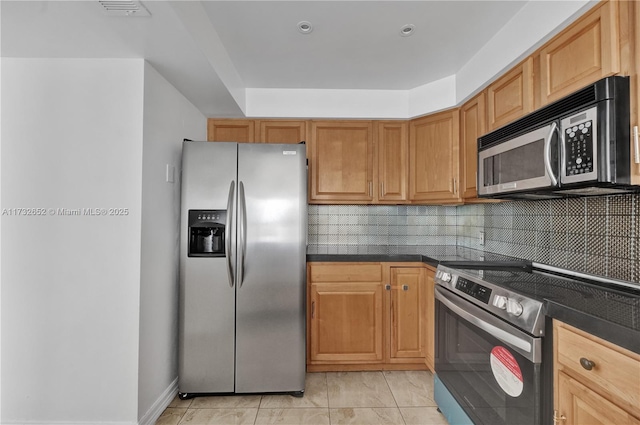 kitchen with tasteful backsplash, appliances with stainless steel finishes, and light tile patterned floors