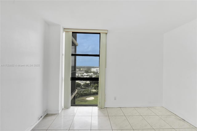 tiled spare room featuring floor to ceiling windows